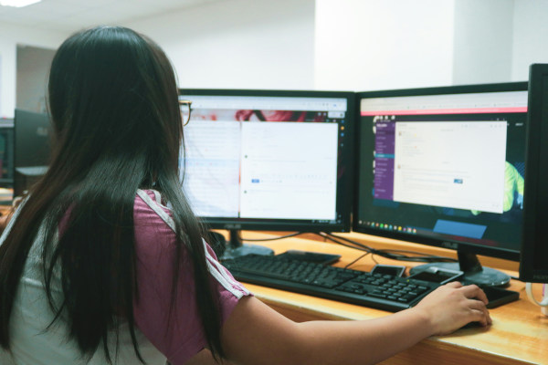 Girl sitting at a computer coding